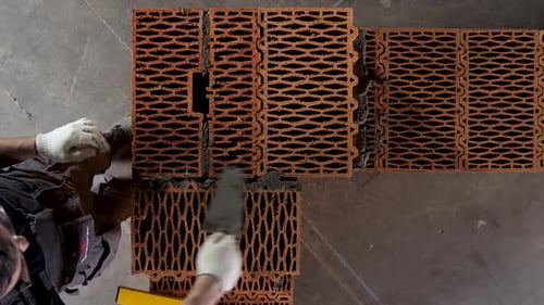Construction Worker Building a Brick Wall with Mortar and Level