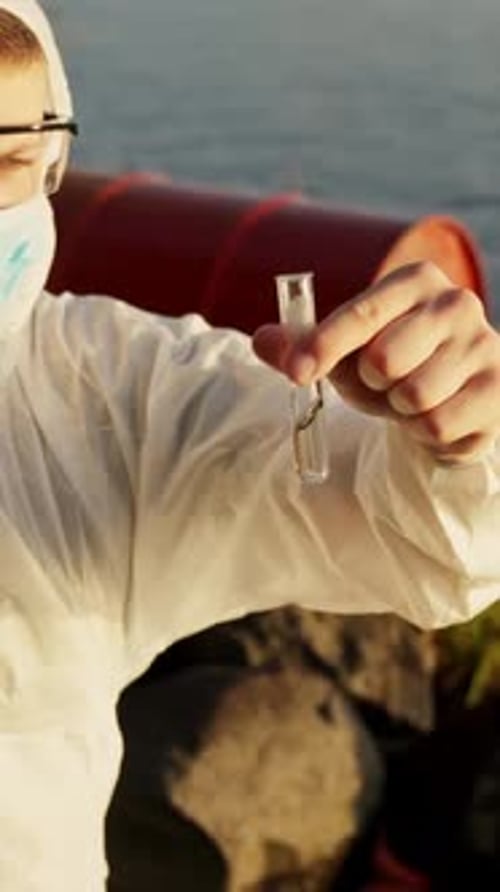 Man in lab suit examines sample