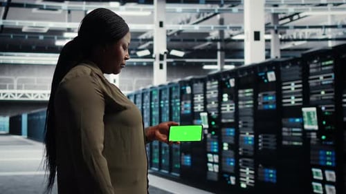 Admin Working in Data Center During Equipment Checkups for Mainframe Operations