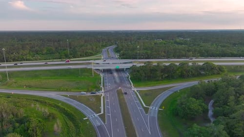 View From Above of Busy American Highway Crossroads with Fast Moving Traffic in Green Florida Area