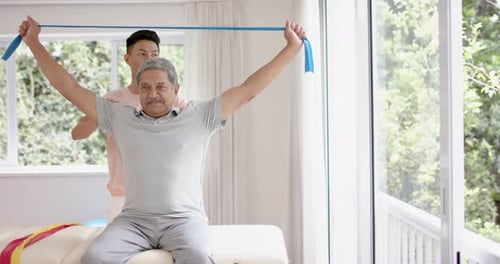 Senior Adult Exercising With Resistance Band in Sunny Room