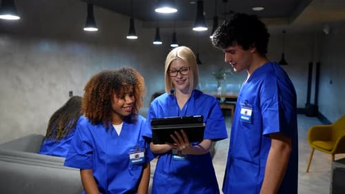 Diverse medical students discussing patient diagnosis on tablet