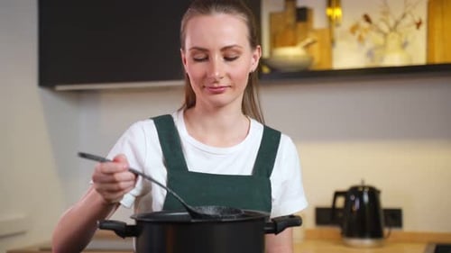 Woman Tasting Soup in Bright Modern Kitchen
