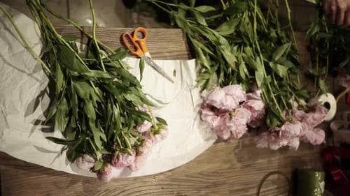 Florist Crafting Bouquet. Florist at Work. Florist makes bouquet in flower shop in Lviv Vertical