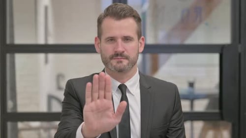 Man Gesturing Stop with Palm Facing Camera