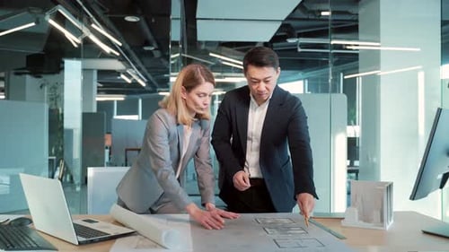Architects Reviewing Blueprints in a Modern Office