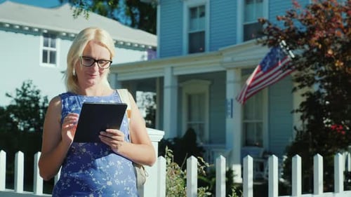 Woman Uses Tablet in Suburban Setting with US Flag