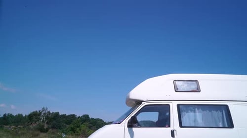White Camper Van Parked in Green Field