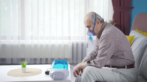 Un vieil homme malade sous respirateur pensif.