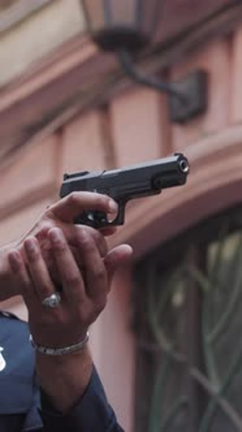 A Police Officer Armed with a Firearm is Positioned in an Urban Setting Ready for Action