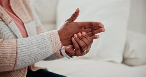 Hände massieren, Schmerzen und Arthritis, Krankheit oder Krankheit im heimischen Wohnzimmer