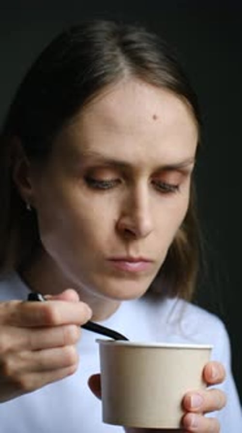 Woman Office Worker Eats Soup with Spoon Holding Plastic Bowl