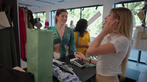 A customer makes a quick and secure payment using their smartphone in a fashion store. woman complet