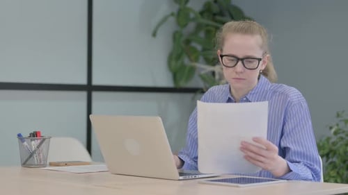 Woman Working on Laptop in an Office