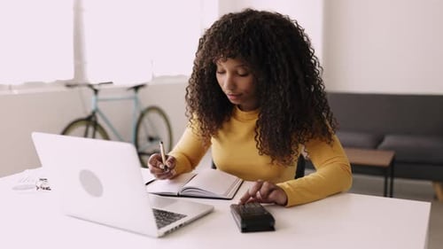 Young Business Woman Working with Computer and Calculator at Home