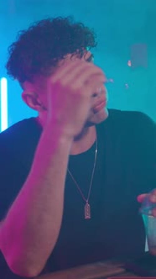 Man with Curly Hair Adjusting and Talking in Club