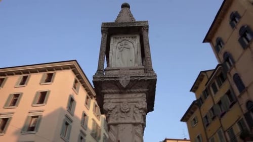 Low angle view ancient devotional column shrine in Verona. Smooth tracking shot.