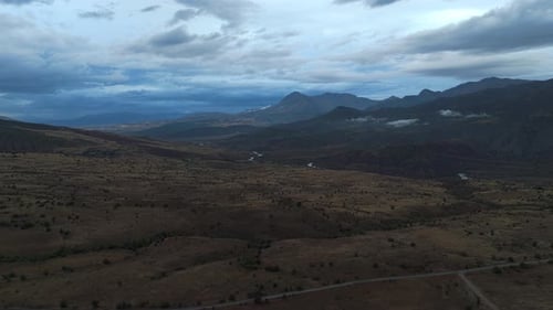 Aerial view a mountain range with a cloudy sky