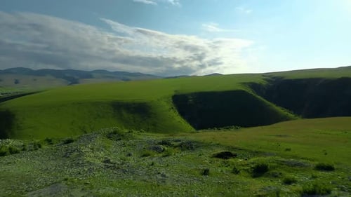 Green Field with Hills and Clouds