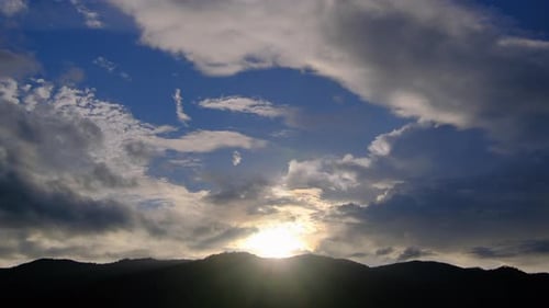 Dramatic Clouds and Golden Sunlight Over Mountain Range