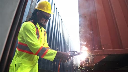 Man Welding Metal Container Structure Outdoors