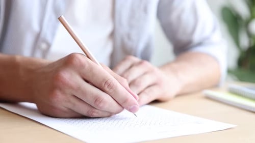Student filling out multiple choice test at table in class, closeup. Passing exam