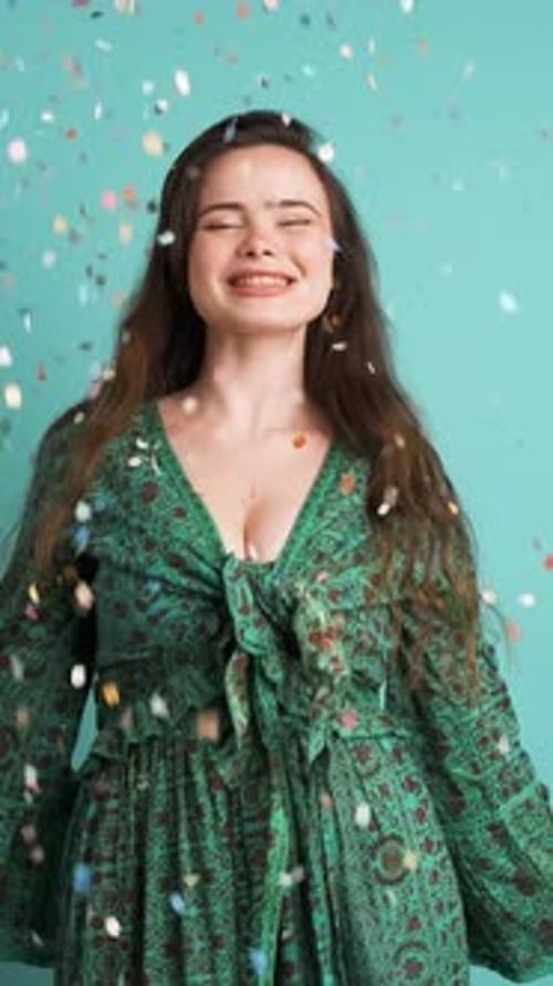 Woman Celebrates with Confetti on Blue Backdrop