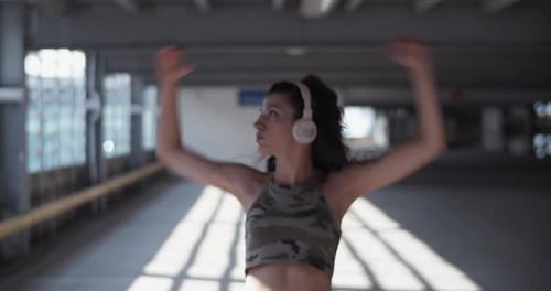 Young Woman Energetically Dancing in Urban Parking Garage