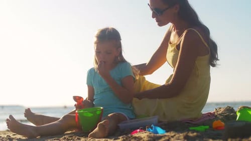 Familien-, Freizeit- und Menschenkonzept — Mutter und Tochter spielen mit Sand