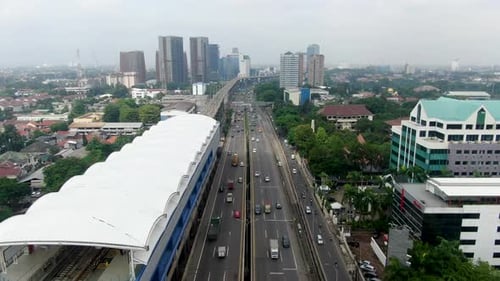 Forward aerial of highway traffic and MRT train tracks in Jakarta