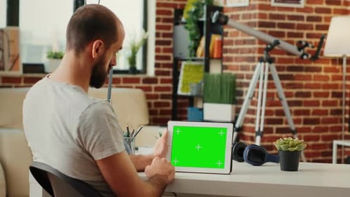 Man at Desk Using Tablet with Green Screen