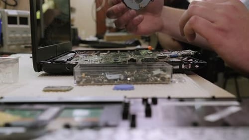 Ein Mann repariert einen Computer entfernt eine Elektronisch Leiterplatte auf einem Desktop