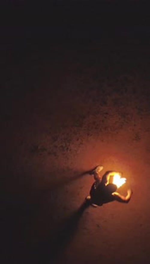 Person Dancing with Fire Sticks at Night