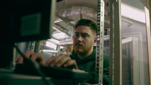 focused hacker in data center hacking software system vulnerable cyber security server room