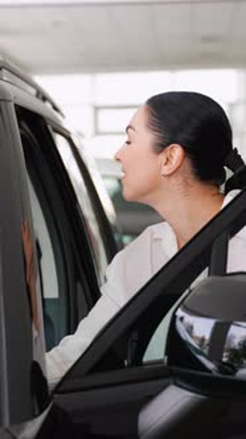 Woman Inspecting a Car Before Purchase at Dealership Showroom