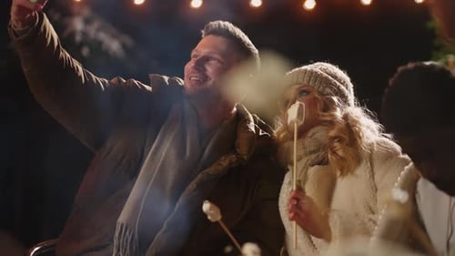 Happy Loving Couple in Friends Party Outdoor in Winter Take Selfie By Smartphone Streaming Stories