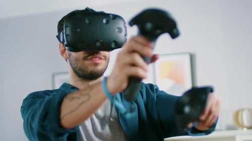 Man Wearing VR Headset and Using Controllers at Home
