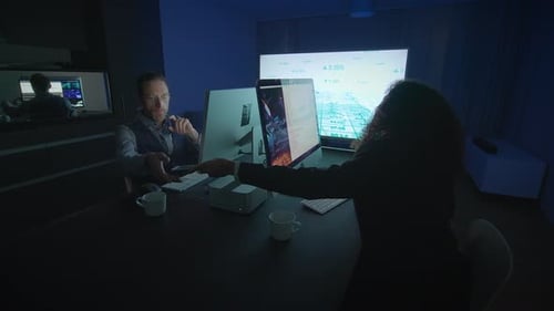 Two Adults Working on Computers at Night