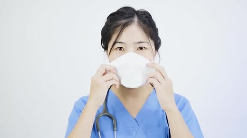 Close-up video of an Asian female nurse wearing a mask.