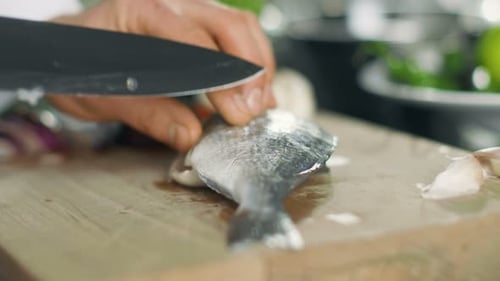 Close-up of a Chef Masterfully Cutting Fish on a Kitchen of a Famous Restaurant.