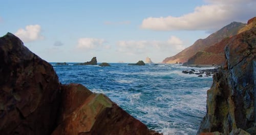 Wellen brechen auf Felsen in einem blauen Meer. Meereswellen am schönen Strand, Wasser prallt gegen eine Leere