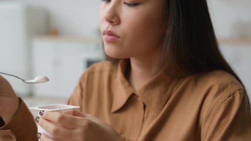 Close Up View Asiana Korean Woman Eat Breakfast Yogurt with Spoon at Home Kitchen Japanese Girl