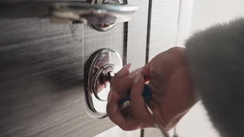 Person Gently Turns Key in Contemporary Door Lock System Close Perspective of Hand Operating Sleek