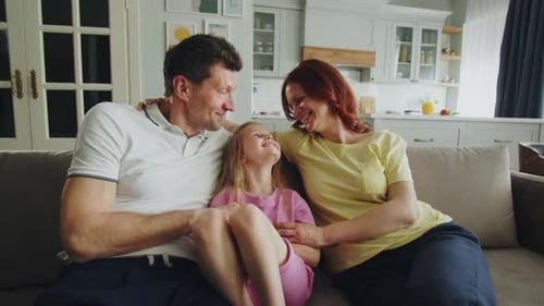 Family Cuddling Together on Couch at Home