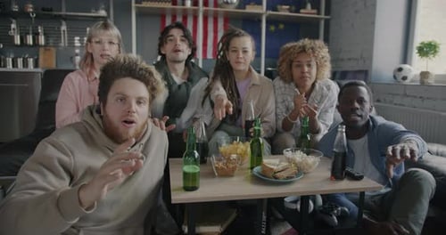 Friends Cheering While Watching a Game at Home