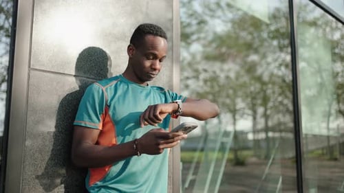 Man Using Mobile Phone Next to Building