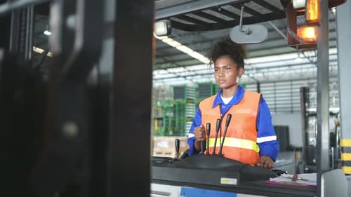 Worker in auto parts warehouse use a forklift to work to bring the box of auto parts