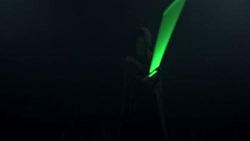 Junger Mann im Cosplay-Kostüm mit Lichtschwertkampf auf schwarzem Hintergrund in Smoke and Rain Slow