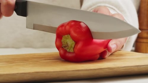 Cutting Red Bell Pepper on Wooden Board