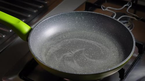 Eggs Being Poured Into Frying Pan on Stove